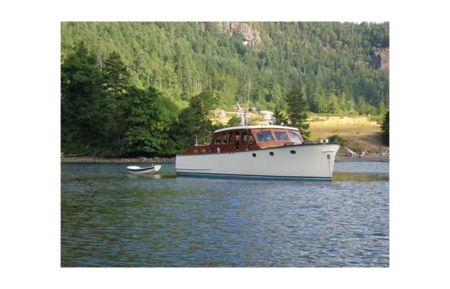 Classic wooden twin diesel cruiser, in water starboard side view