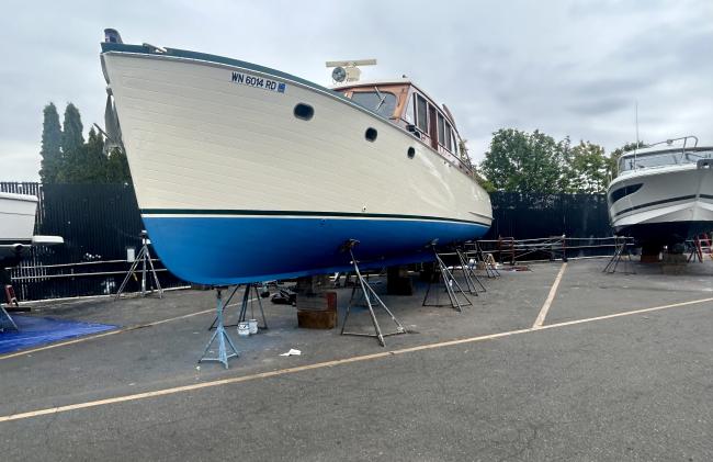 Classic wooden twin diesel cruiser, on the hard bow port side view
